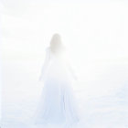 Ethereal figure in white dress in misty snowscape