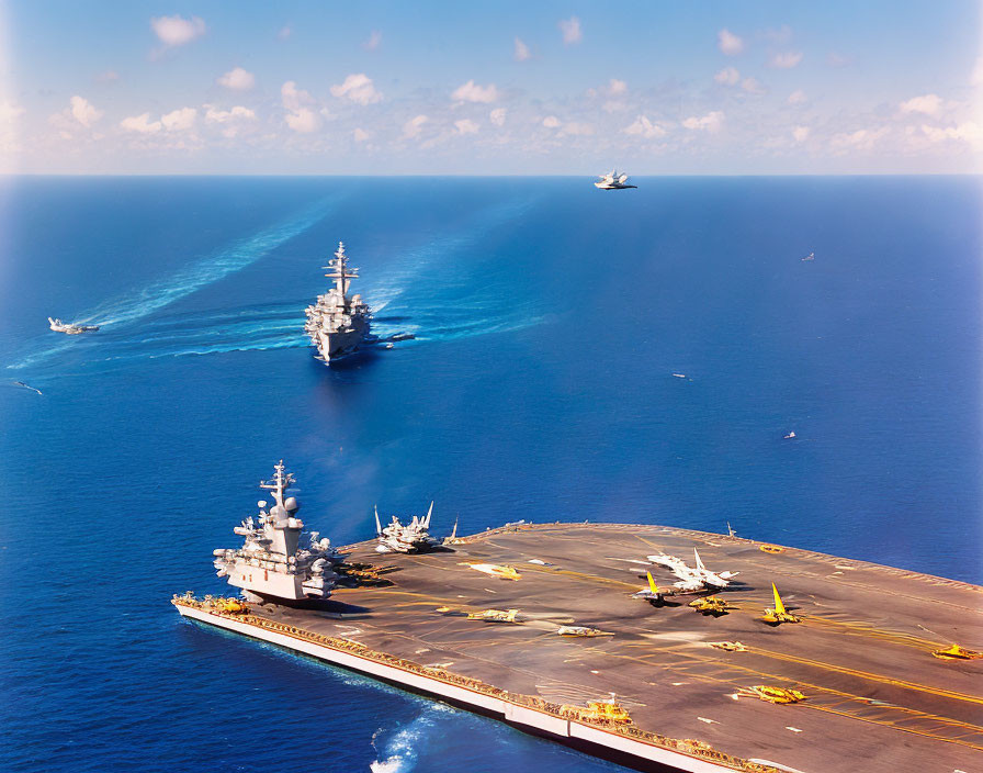 Naval aircraft carrier with planes on deck at sea