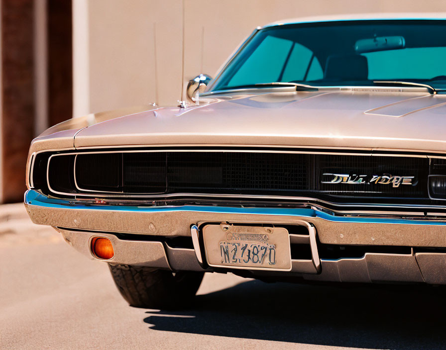 Classic Dodge vehicle grille and headlight in close-up view with blurred background