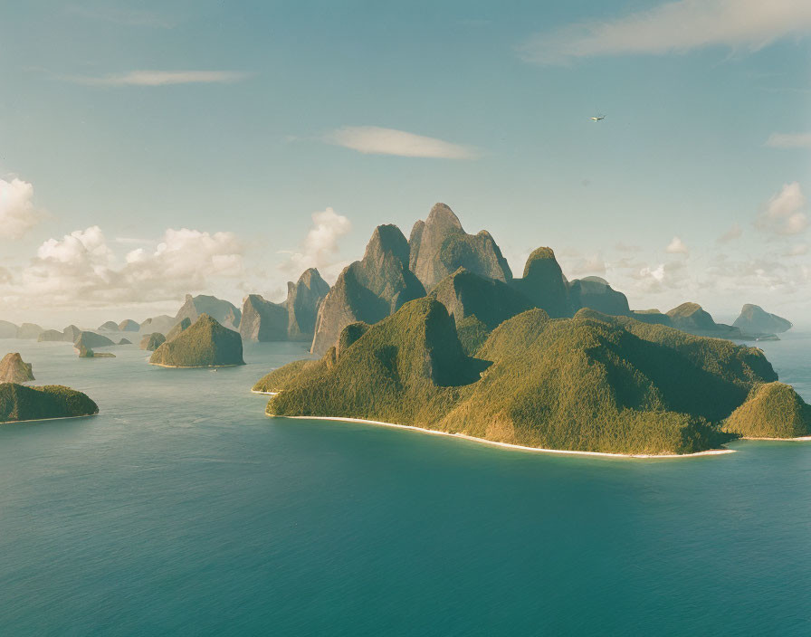 Tranquil seascape with green islands, karst mountains, and distant aircraft