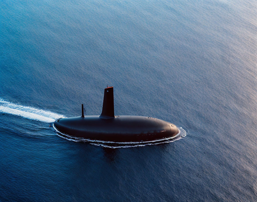 Silhouette of a submarine on ocean surface at sunset