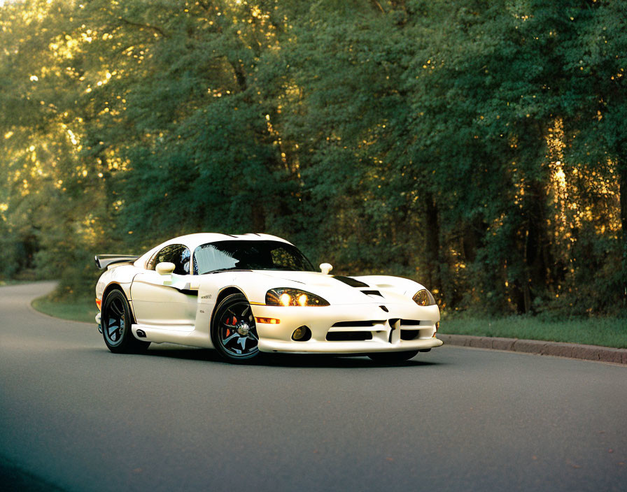 White Sports Car with Black Stripes Parked on Road Amid Greenery