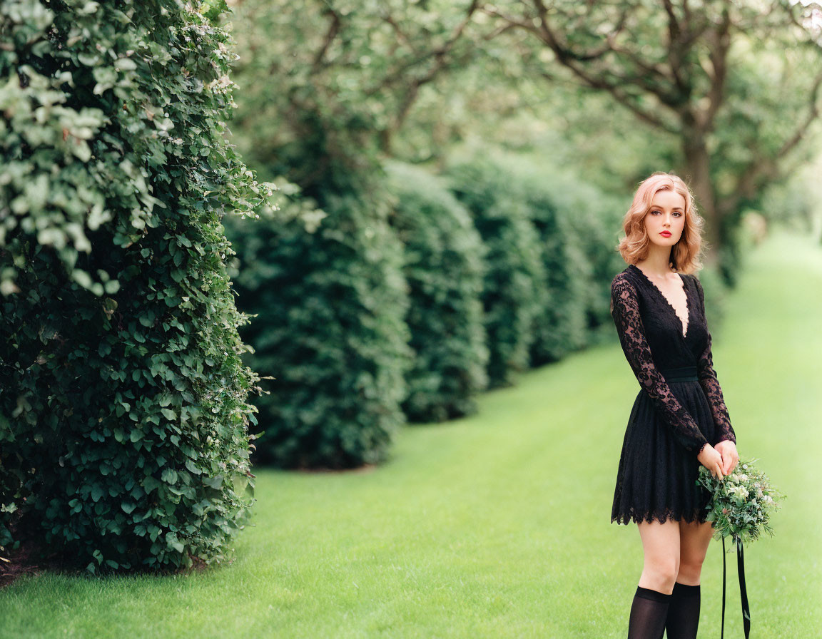 Woman in Black Lace Dress with Bouquet on Grassy Pathway