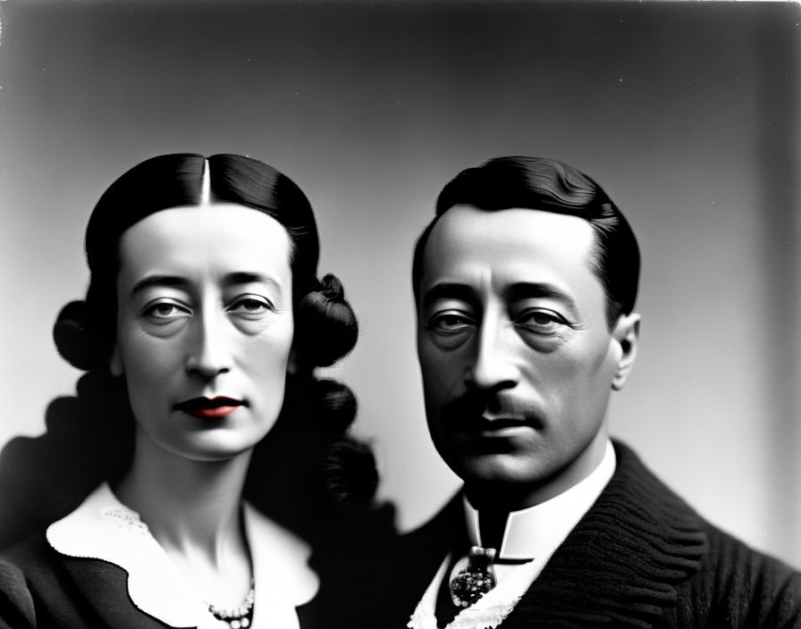 Monochrome portrait of serious couple with curly hair and formal attire