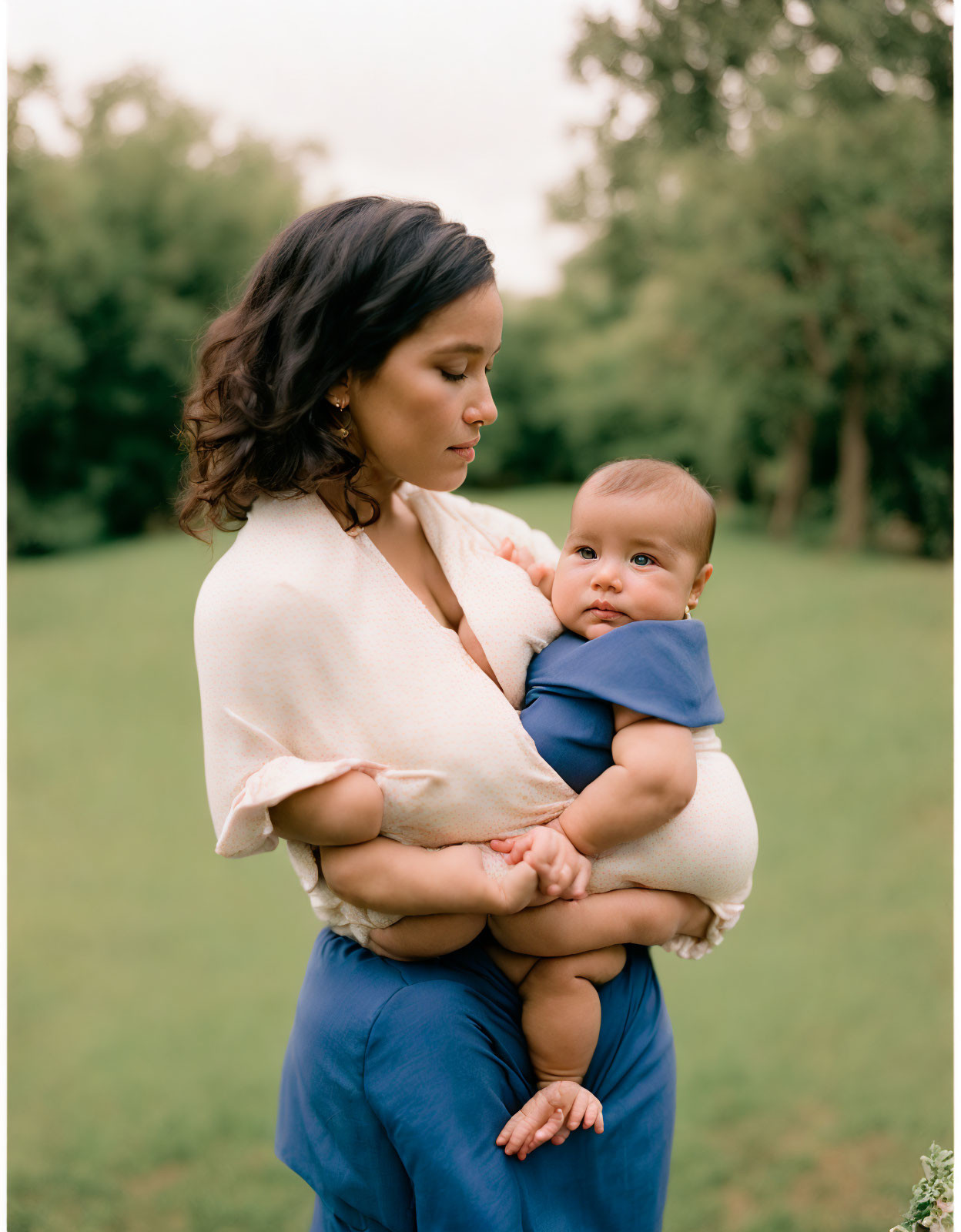 Woman with Baby in Green Field, Cream Blouse, Blue Pants