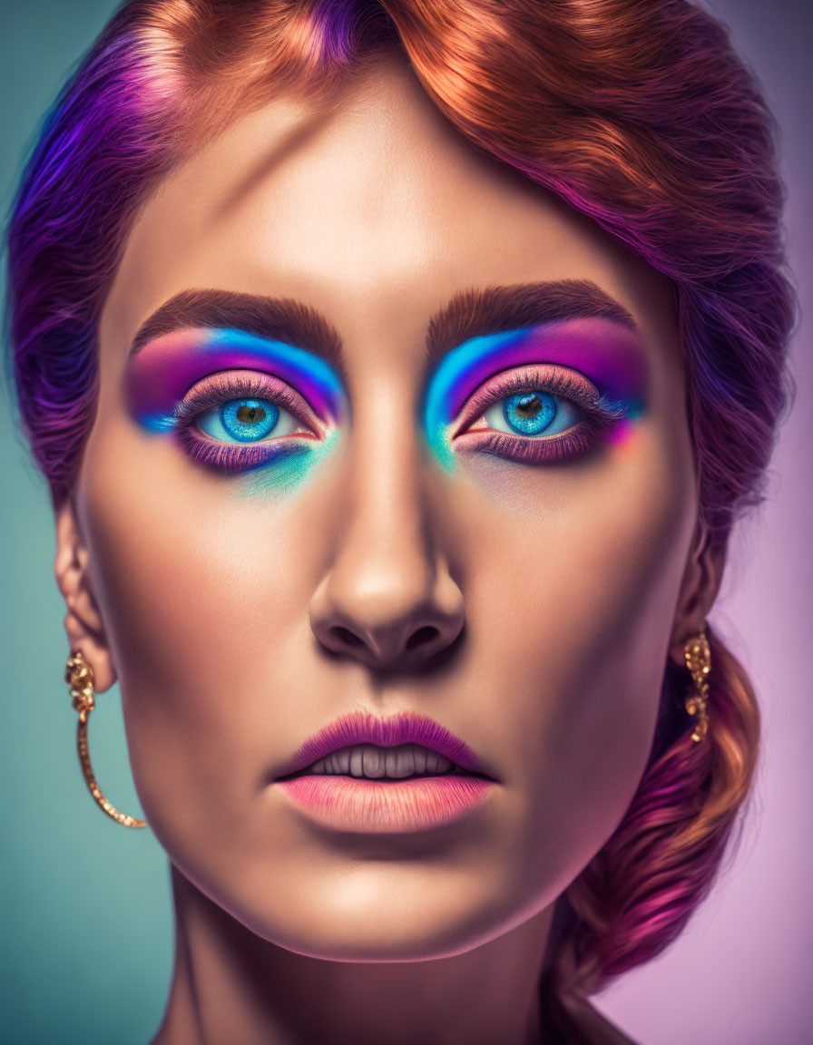 Vibrant blue and purple eyeshadow on a woman with striking blue eyes and auburn