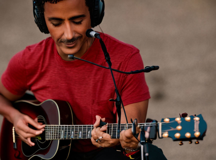 Musician in Red Shirt Playing Acoustic Guitar and Singing into Microphone