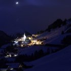 Serenity village under starry night sky with glowing lights