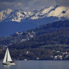 Sailboat on Calm Lake with Snow-Capped Mountains