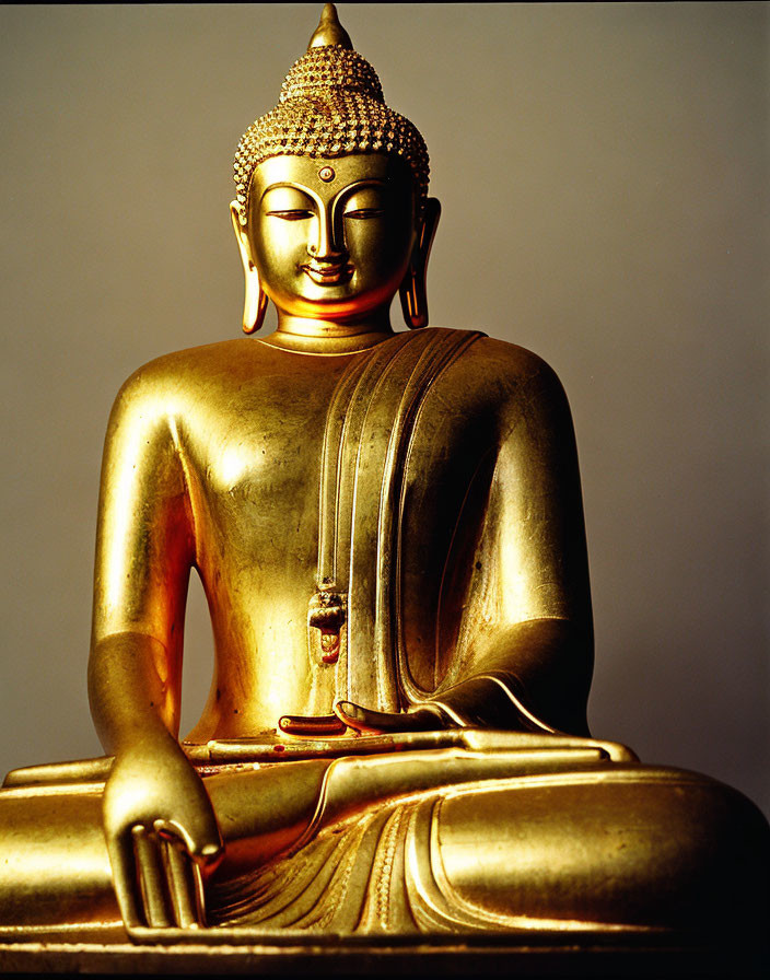 Golden Buddha Statue Meditating on Neutral Background