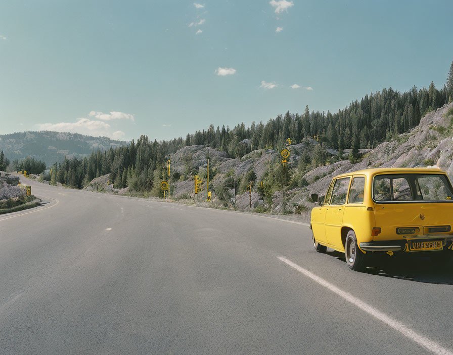 Vintage Yellow Station Wagon on Sunny Mountain Road