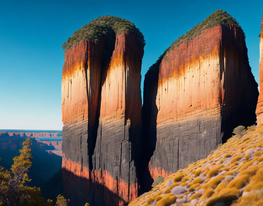 Towering Rock Formations with Vertical Striations on Grassy Plain