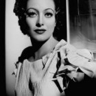 Monochrome portrait of woman with braided hair in floral dress holding white orchid