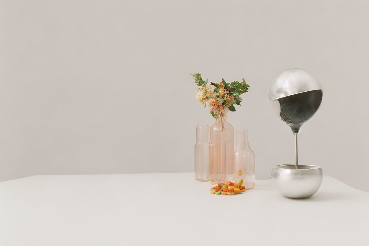 Minimalist Flower Arrangement with Kumquats and Silver Teapot on White Surface