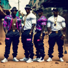 Four men in stylish attire with gold chains and sunglasses posing confidently outdoors