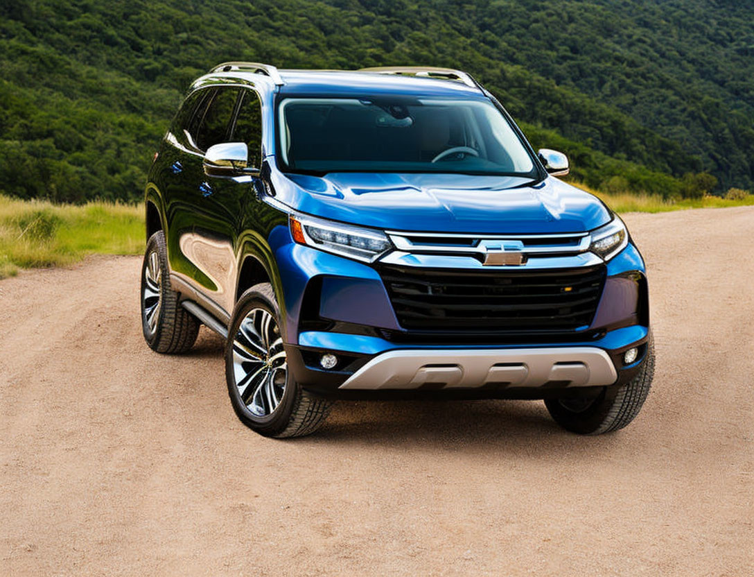 Blue SUV parked on dirt road with lush green hills