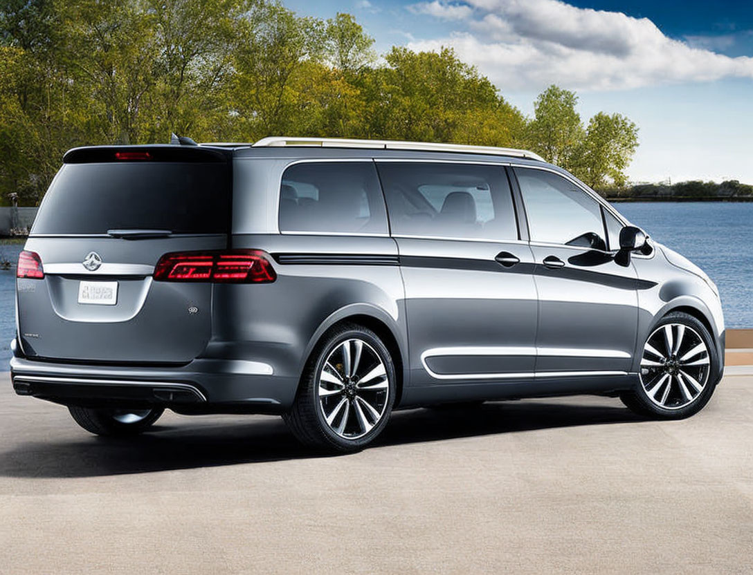 Silver minivan parked by water with sleek design and alloy wheels