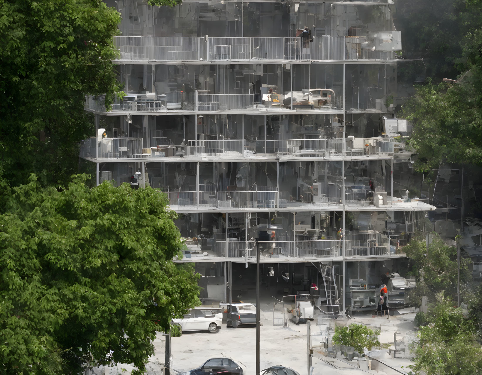 Multi-story building under construction with scaffolding, workers, and scattered materials