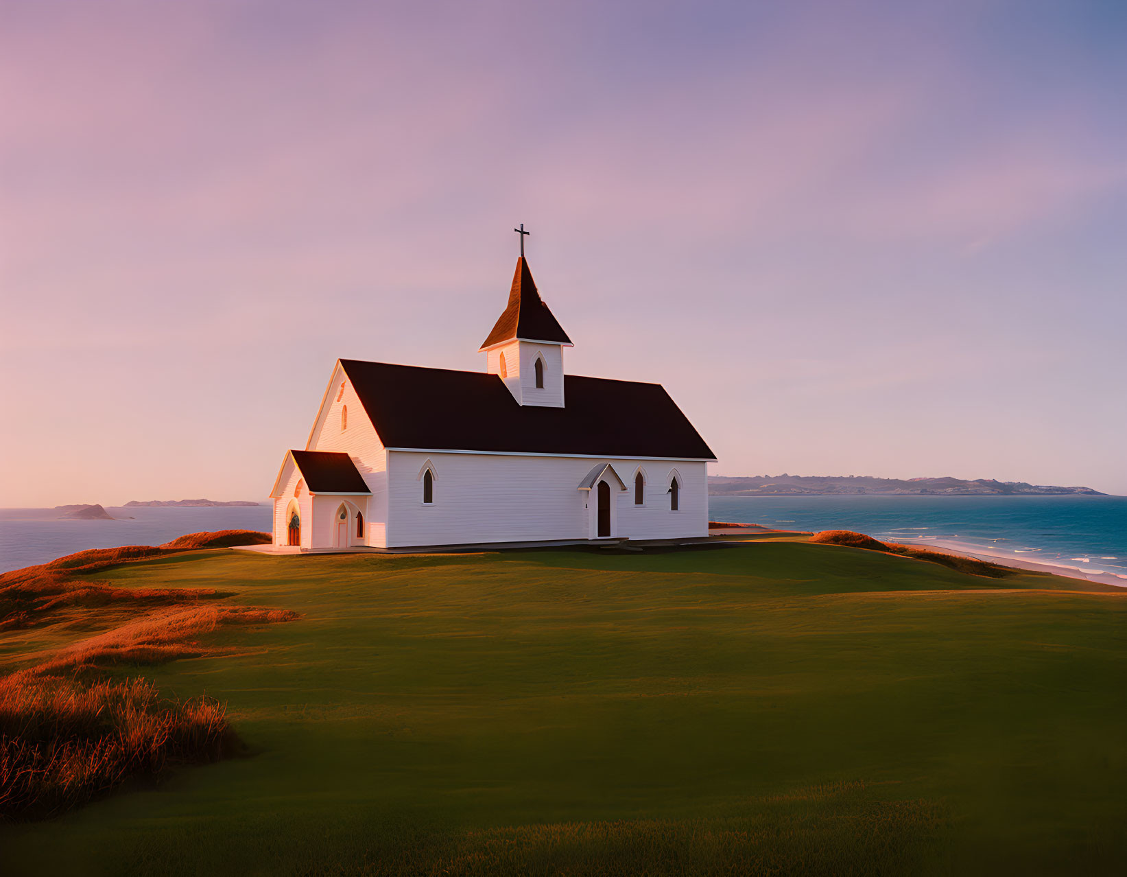 White church with steeple by serene sea and pink sky