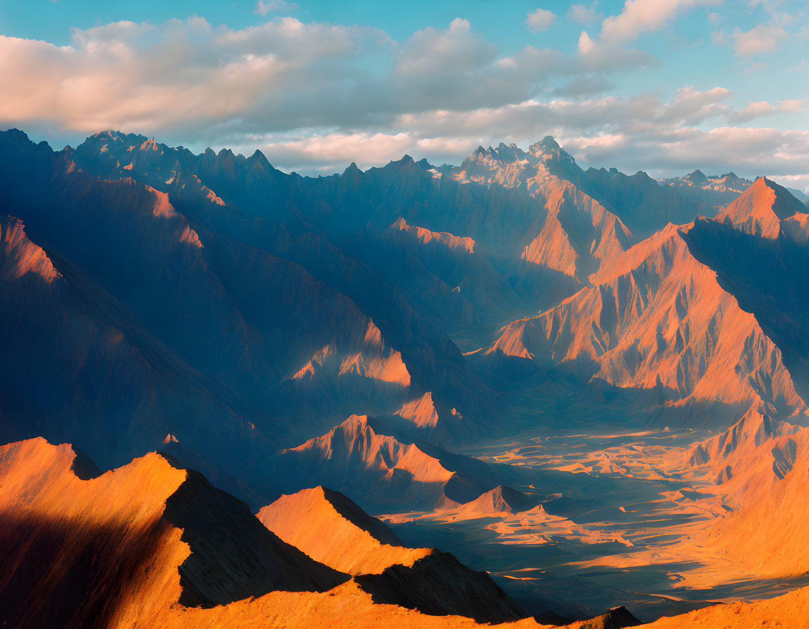 Scenic sunrise over rugged mountain range with deep valleys and prominent peaks