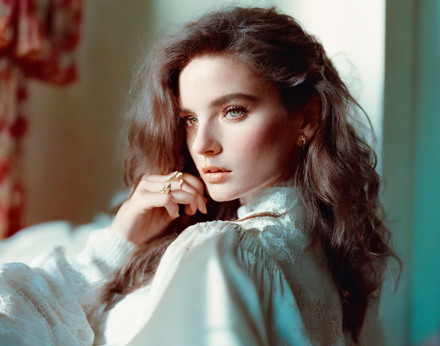 Woman with wavy hair and captivating eyes under warm sunlight.