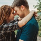 Animated characters in nature sharing a tender moment with foreheads touching