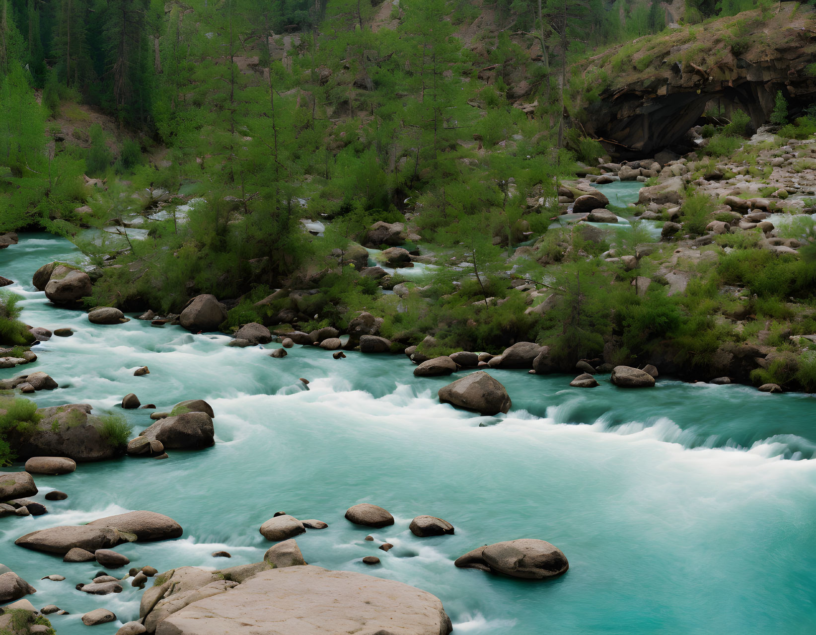 Turquoise River Flowing Through Rocky Terrain and Green Trees