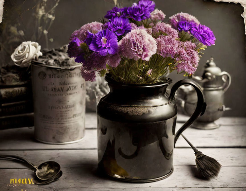 Vintage setting with purple flowers in ornate pitcher, teapot, spoon, and brush.