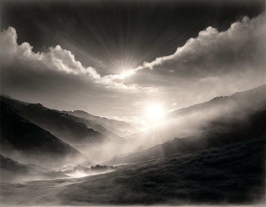 Monochromatic landscape: Sun rays through cloud-covered mountains