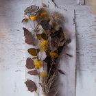 Dried Flowers and Leaves in Vase on Rustic White Wooden Background