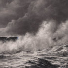 Monochrome artwork of stormy sea with crashing waves and sailboat