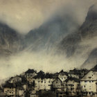 Misty village at base of foggy mountains