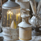 Antique table setting with vintage lantern, candles, rustic vase, and dried plants