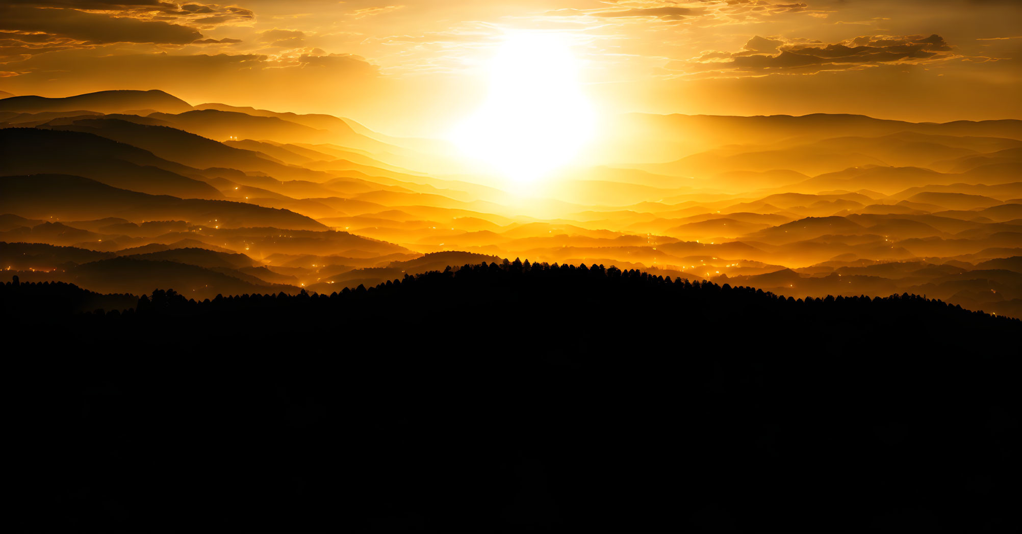 Scenic golden sunrise over layered mountain ridges and hazy sky