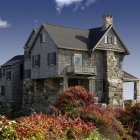 Cozy cottage on staircase amid autumn trees and flying birds