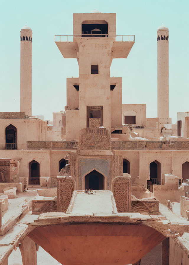 Ornate ancient brick building with towering minarets against blue sky