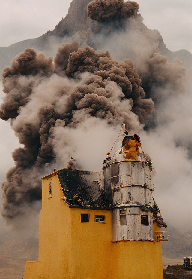 Person in orange watching erupting volcano from yellow building with dark ash clouds.