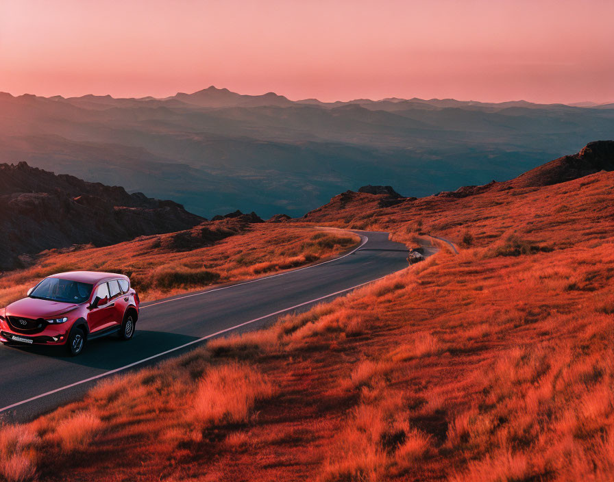 Sunset car drive through hilly landscape with pink-orange sky