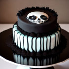 Gothic-themed two-tiered cake with black and white color scheme and spooky decorations