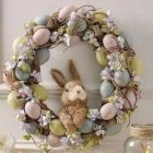 Easter-themed composition with bunny, eggs, blooms, wreath, glassware, and flowers