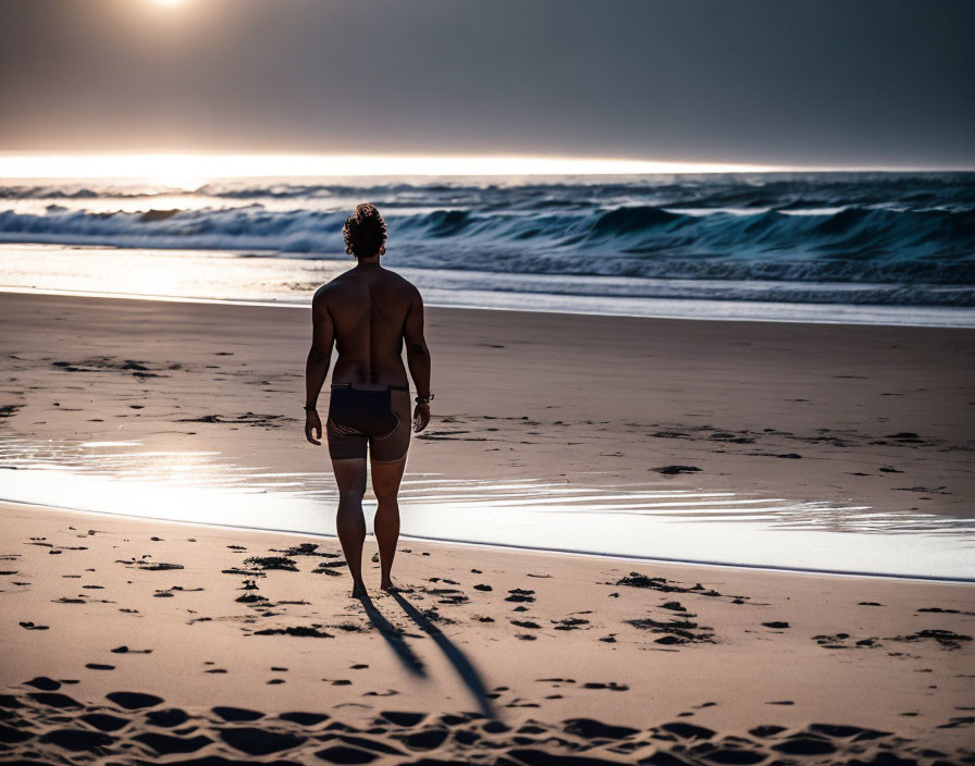 Person on Beach at Sunset Gazing at Ocean with Stretching Shadow