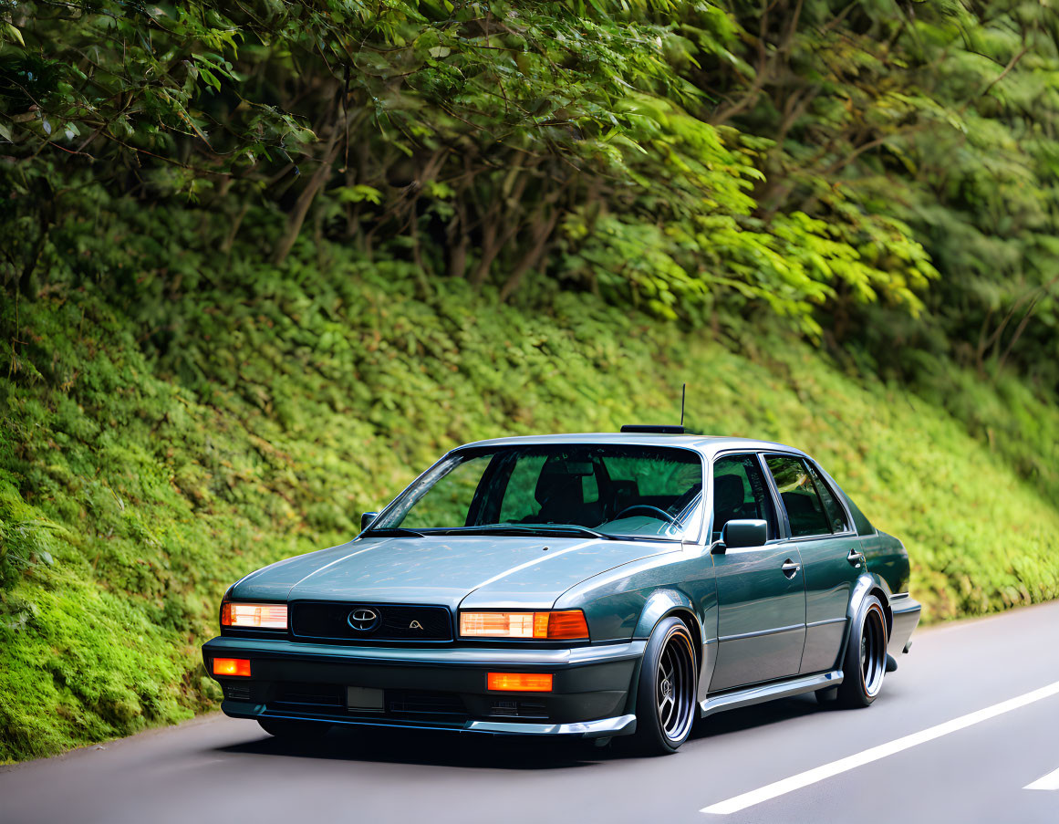 Classic Green Toyota Sedan with Aftermarket Mods Driving Through Lush Greenery