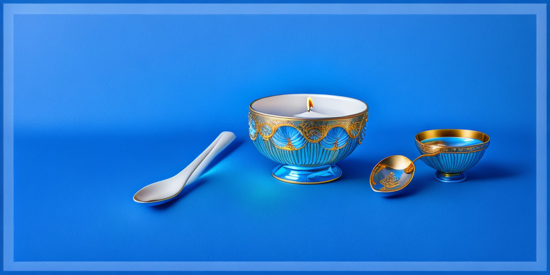 Ornate blue and gold bowl with lit candle on blue background