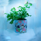 Blue Pot with Intricate Patterns and Greenery, Pink Blossoms, and Floating Petals