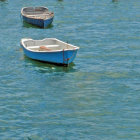 Two Small Boats Floating in Clear Blue Water with Visible Sea Floor