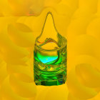 Green liquid splashing into glass on golden yellow background