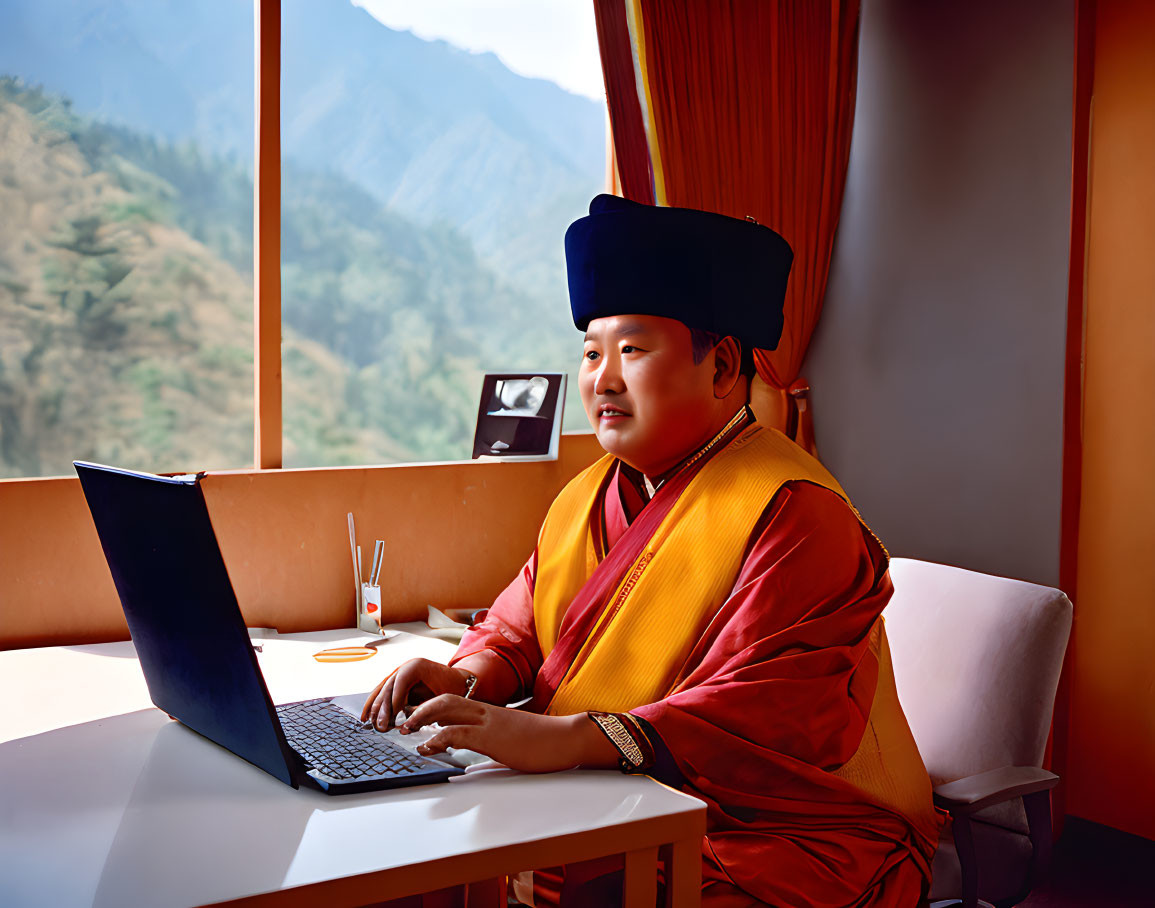 Buddhist monk in traditional robes using laptop with mountain view