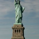 Iconic Statue of Liberty against blue sky and clouds from low angle