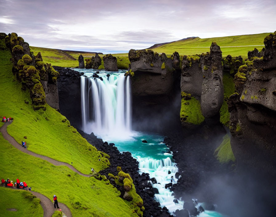 Scenic waterfall surrounded by greenery and basalt columns