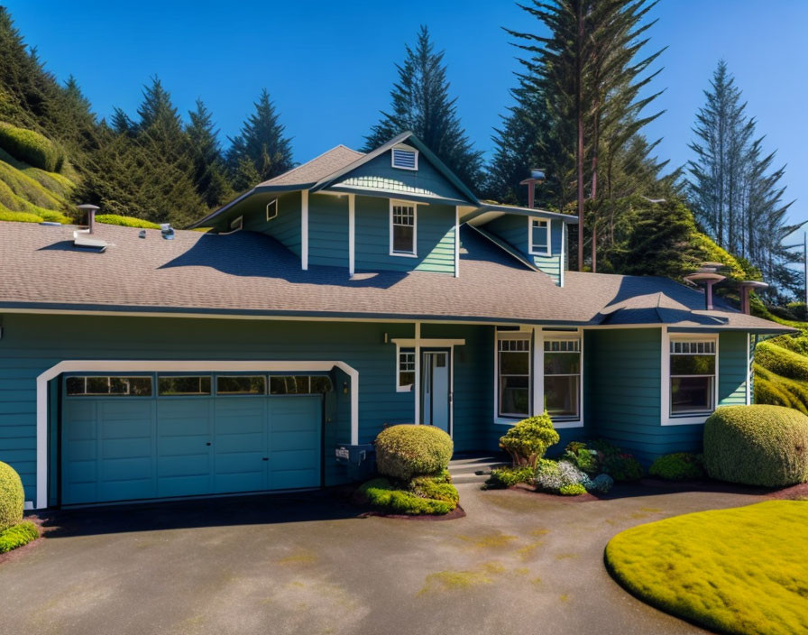 Blue suburban house with two-car garage, landscaped garden, and tall evergreen trees.